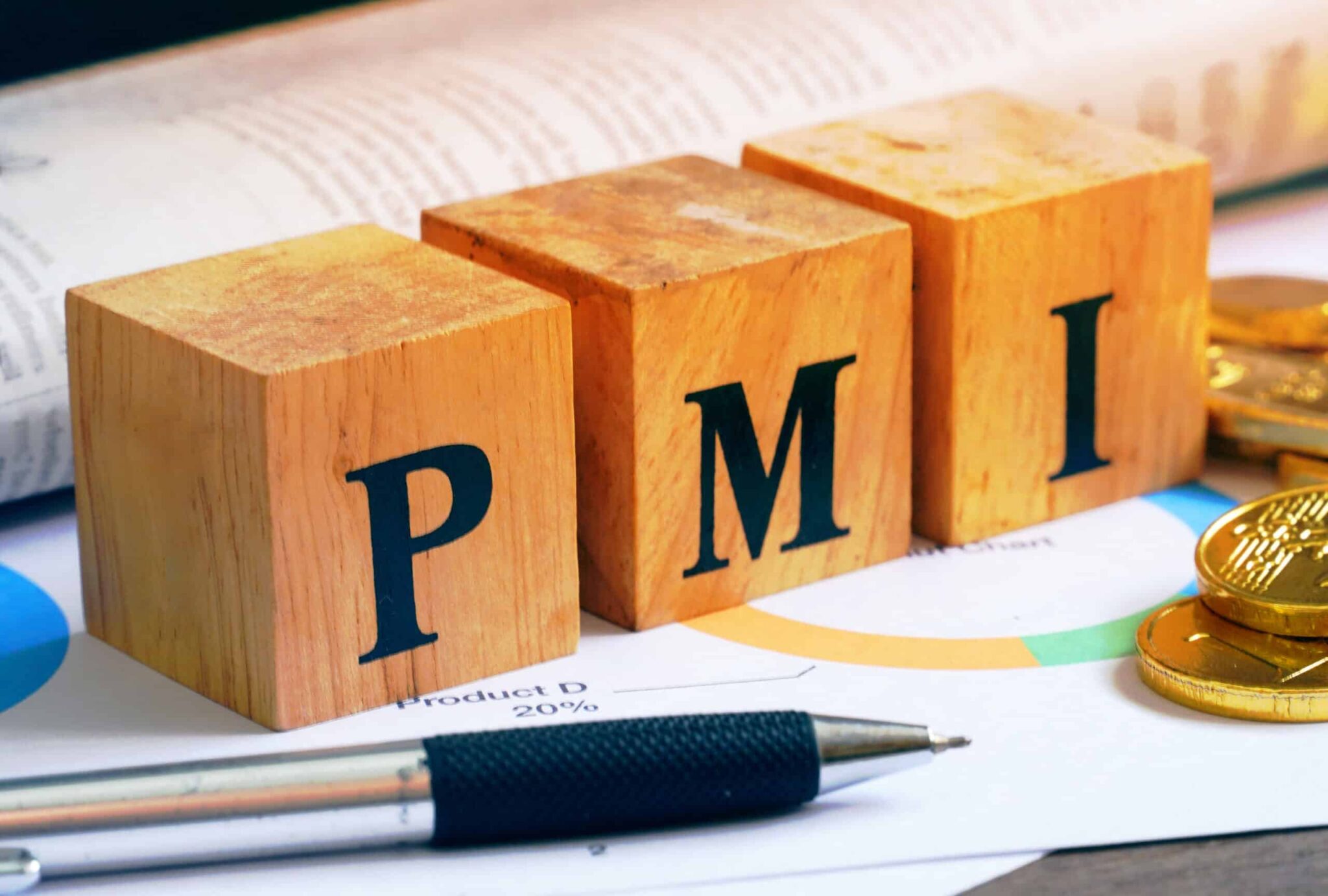Text "PMI" on wood cube with gold bar and newspaper on the table, economic data concept