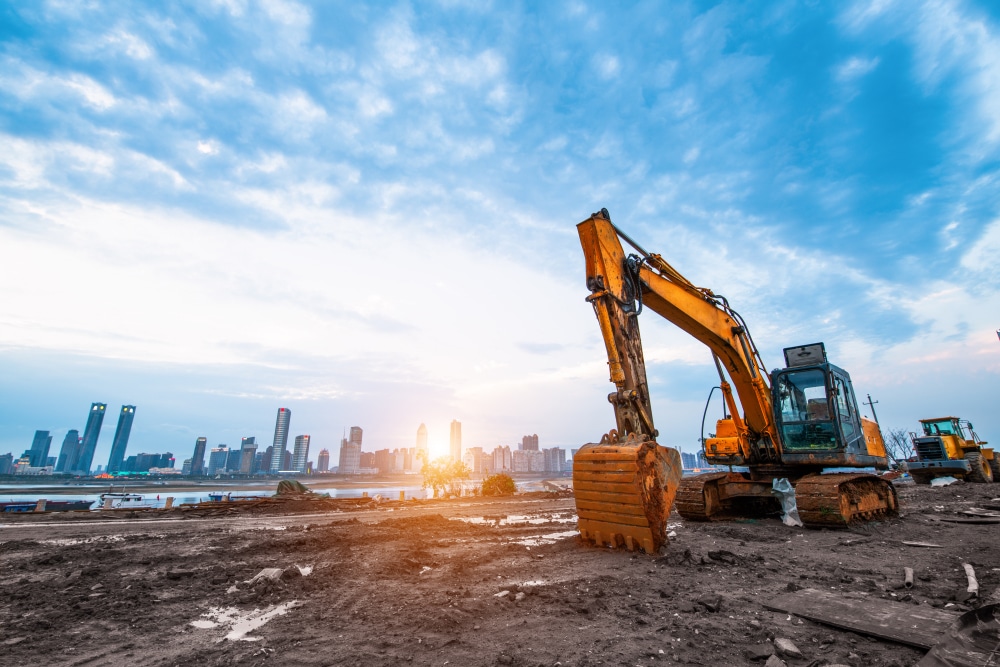 excavator in construction site on sunset sky background